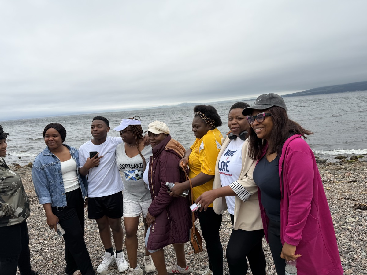A group of women and young people laughing together on the beach