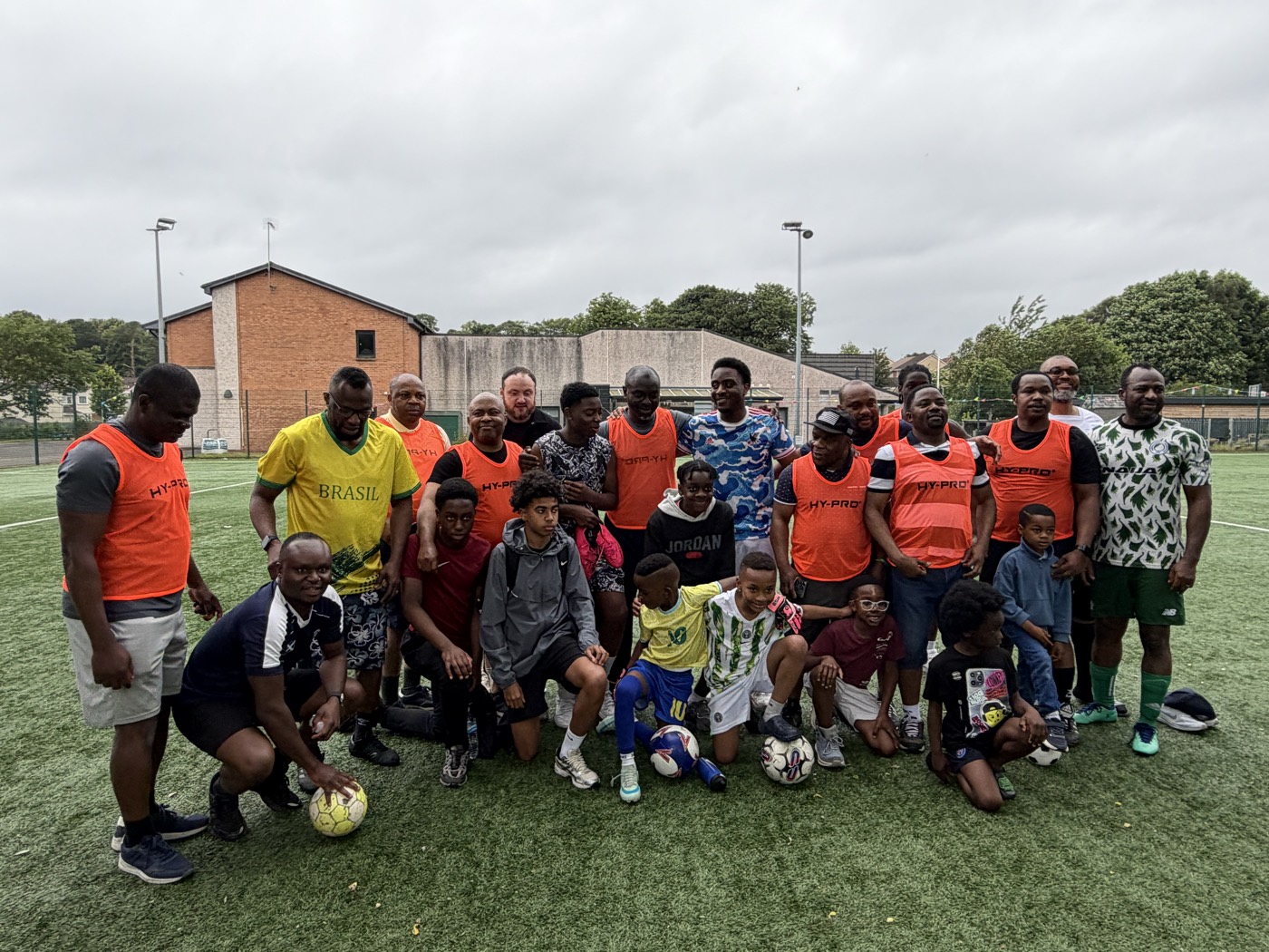 Men and boys in bibs posing after the football match