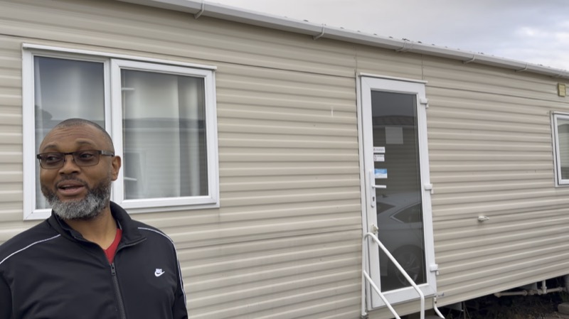 A member standing outside his caravan