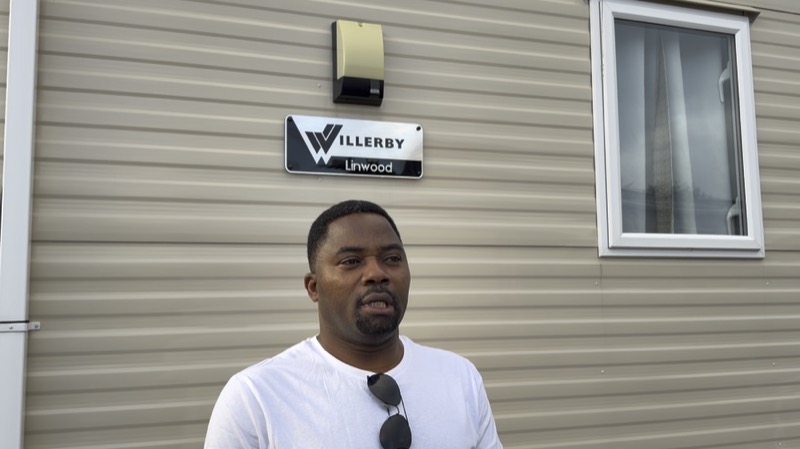 A member standing outside a caravan