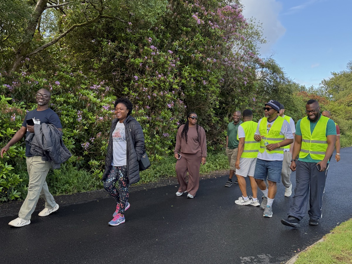 Members walking past rhododendrons in bloom