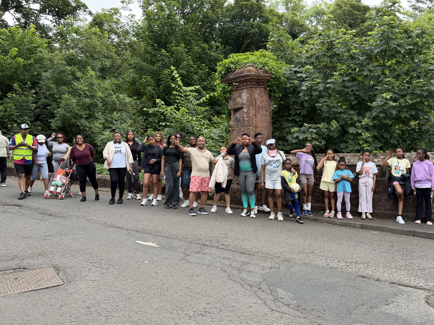 The group lined up along a sandstone wall, waving at the camera